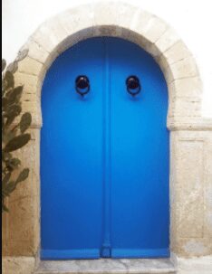 Closeup view of a blue door with black handles