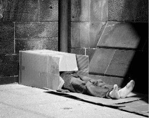 Black and white photo of a man covering his head with a box